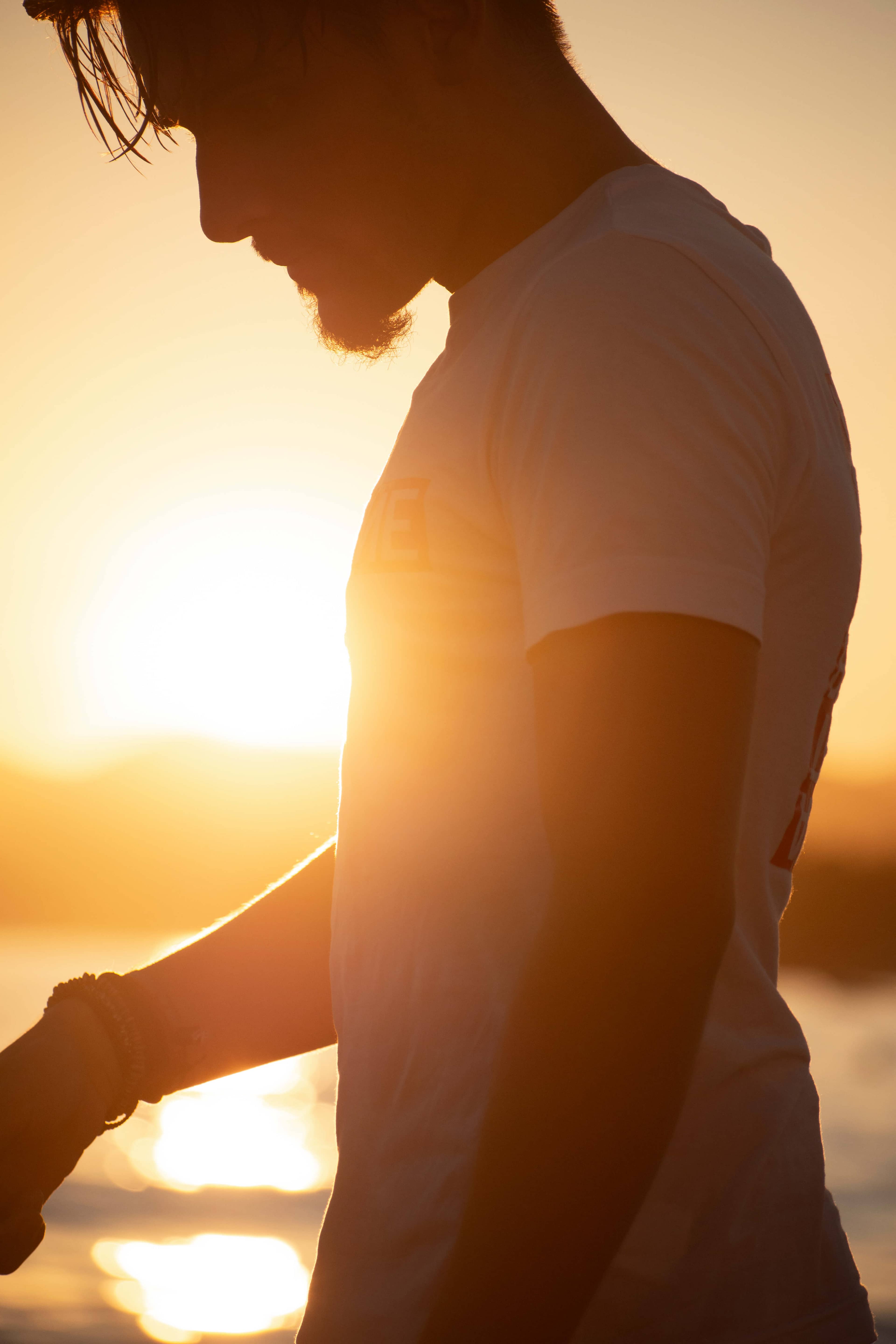 Mathieu en contre jour, au bord de mer avec le soleil qui illumine l'objectif.